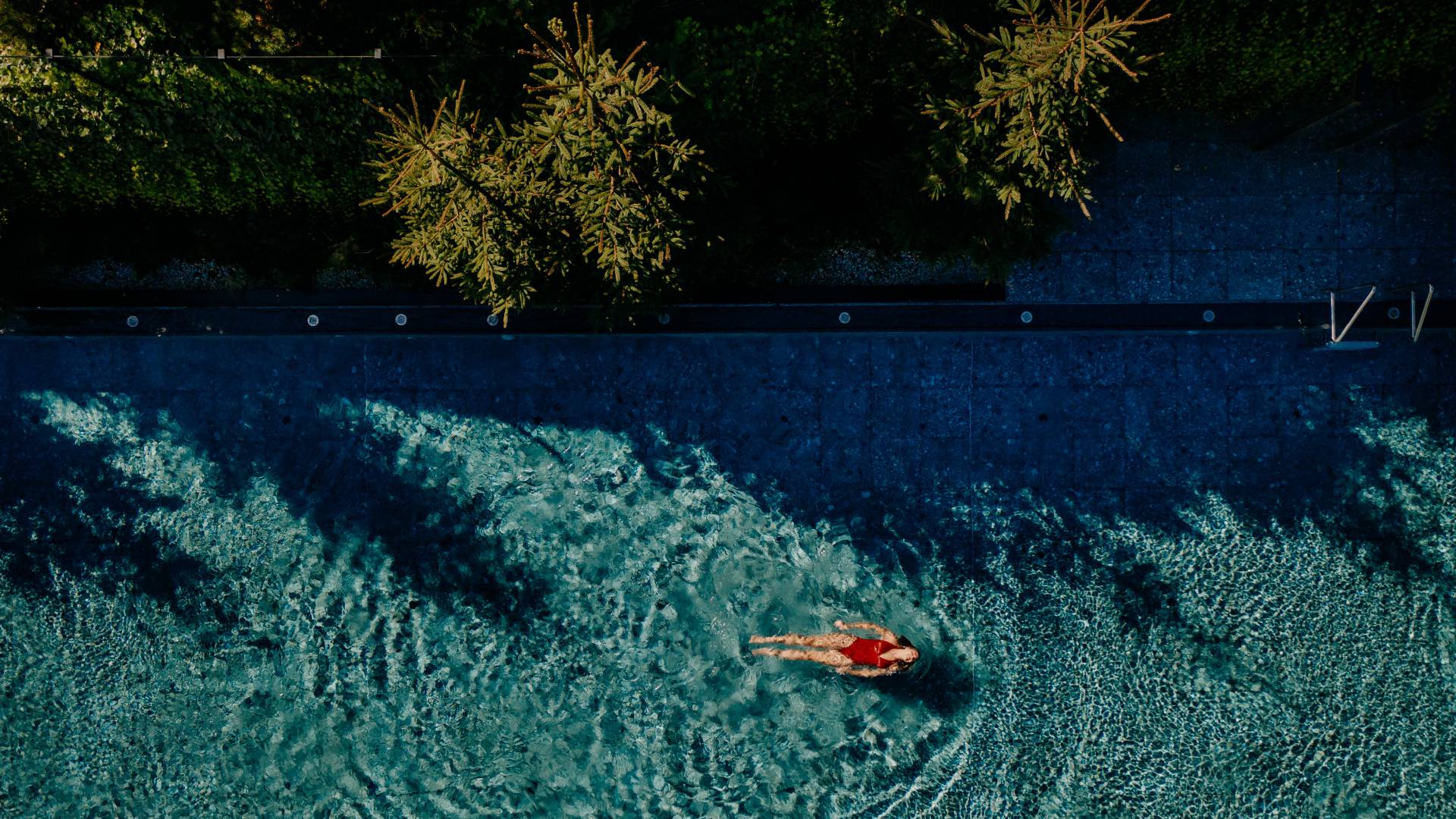 Frau schwimmt im Sportpool des Naturhotel Forsthofgut