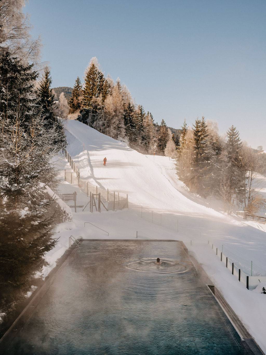 Outdoor pool overlooking ski slope in winter