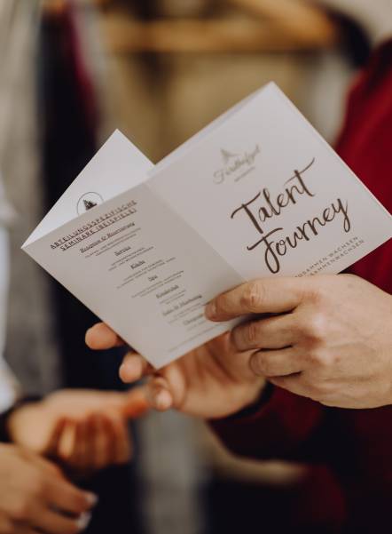 Mann hält Prospekt "Talent Journey" in den Händen
